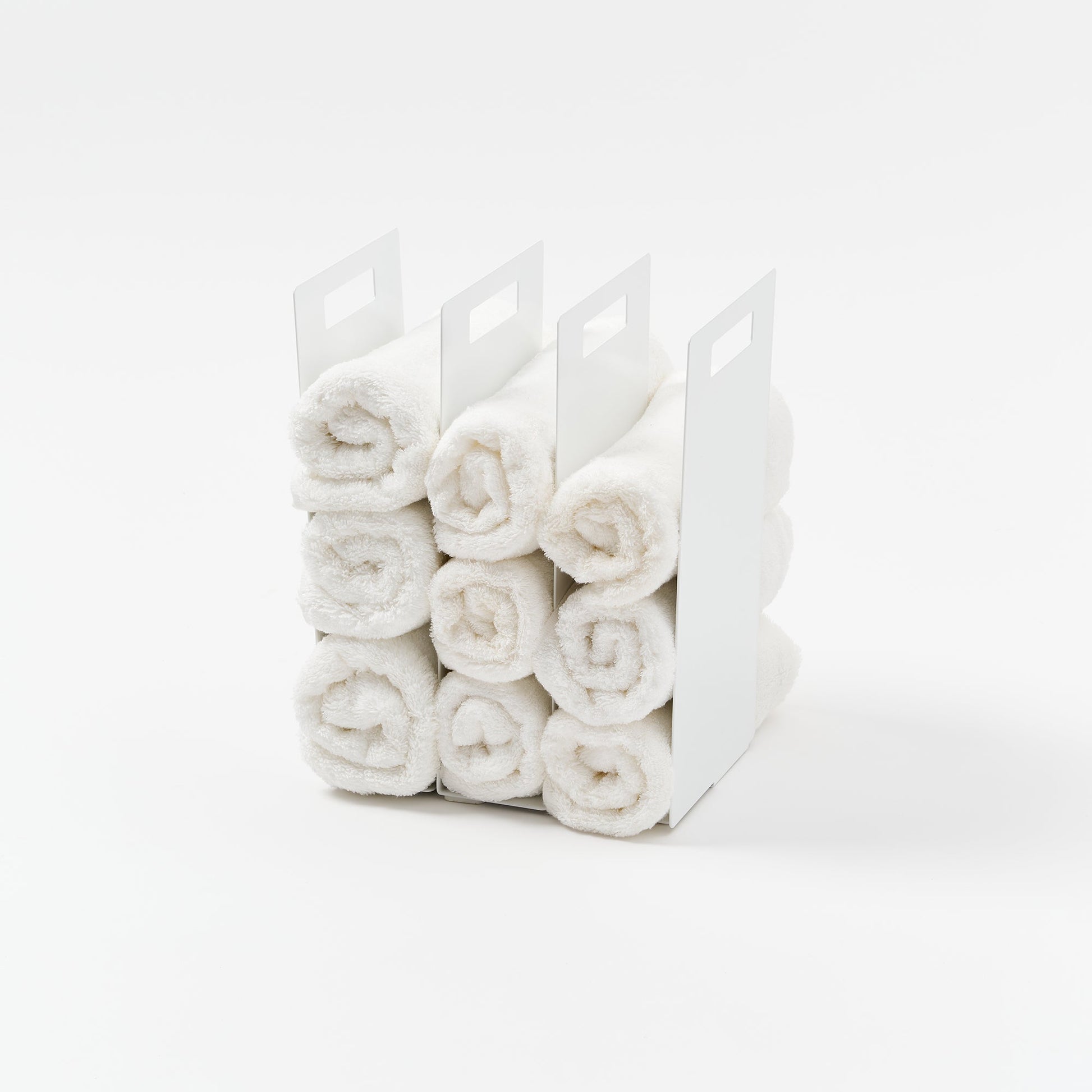 Yamazaki Home Towel Storage Organizer with props, set against a white background.