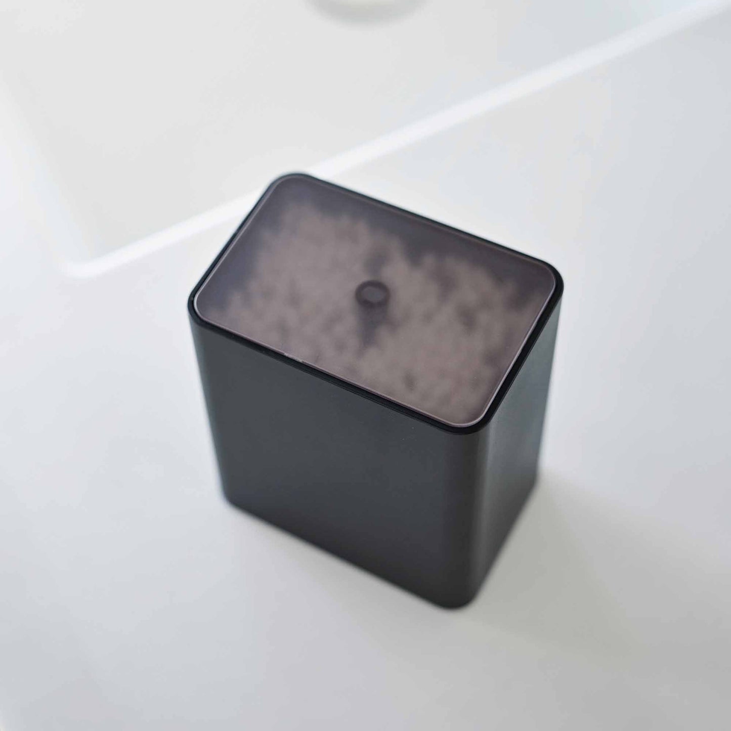Top view of the cotton swab push-top case with the lid on from Yamazaki Home in black.