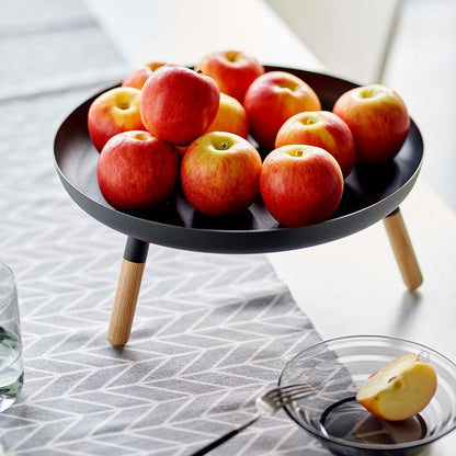 Close up of black Yamazaki Countertop Pedestal Tray with apples on top on a dining table