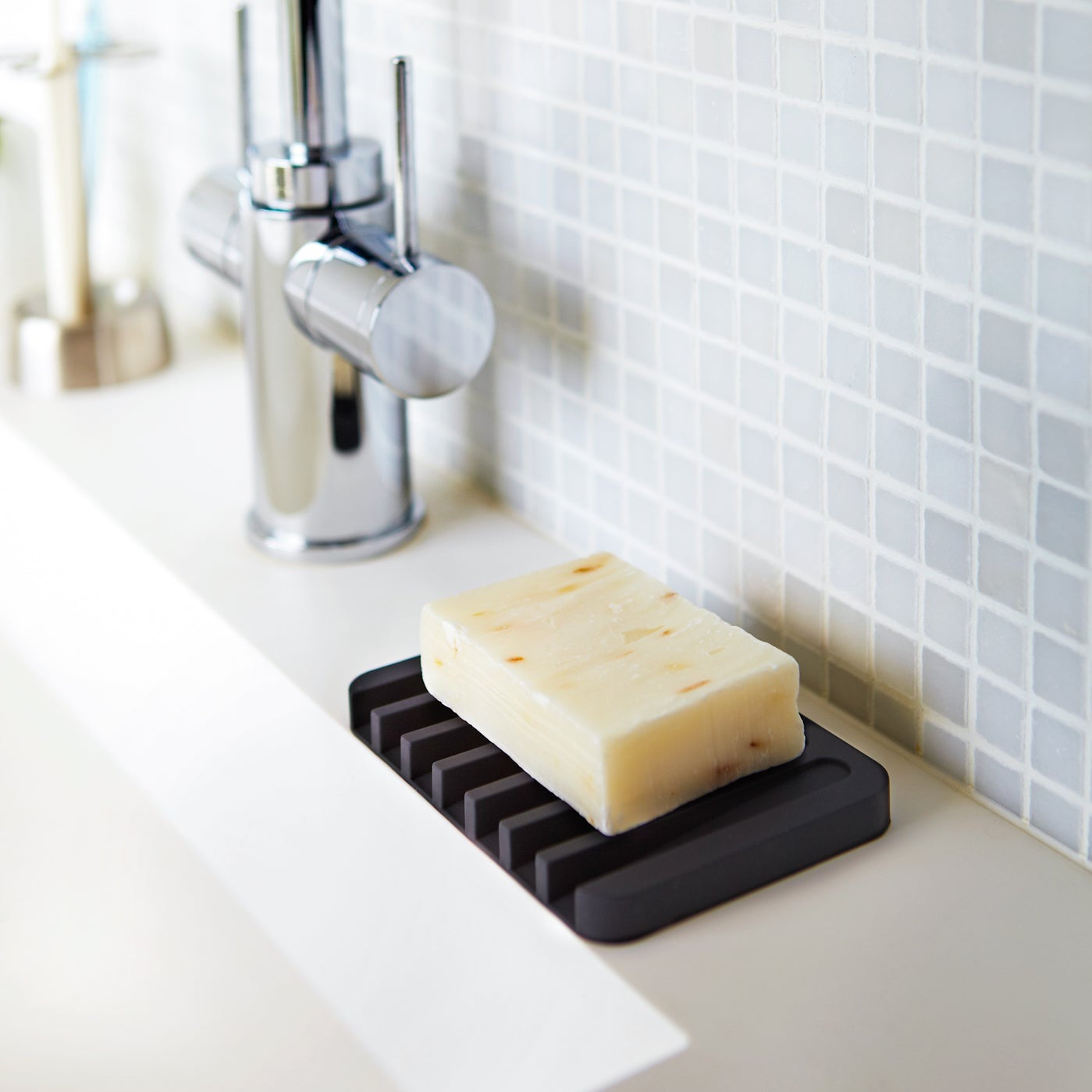 Black Yamazaki Home Self-Draining Soap Tray with soap resting on top