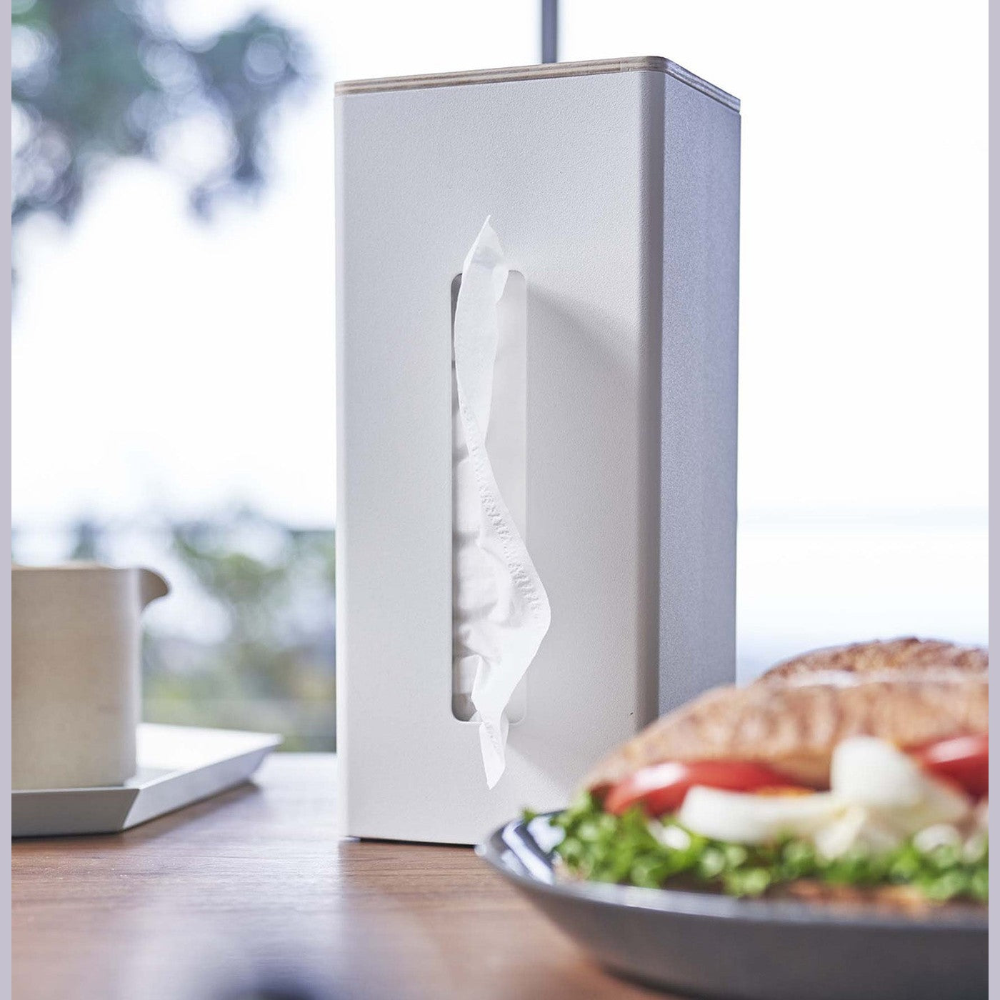 Close up of white Yamazaki Two-Sided Tissue Case with tissues inside on a dining table