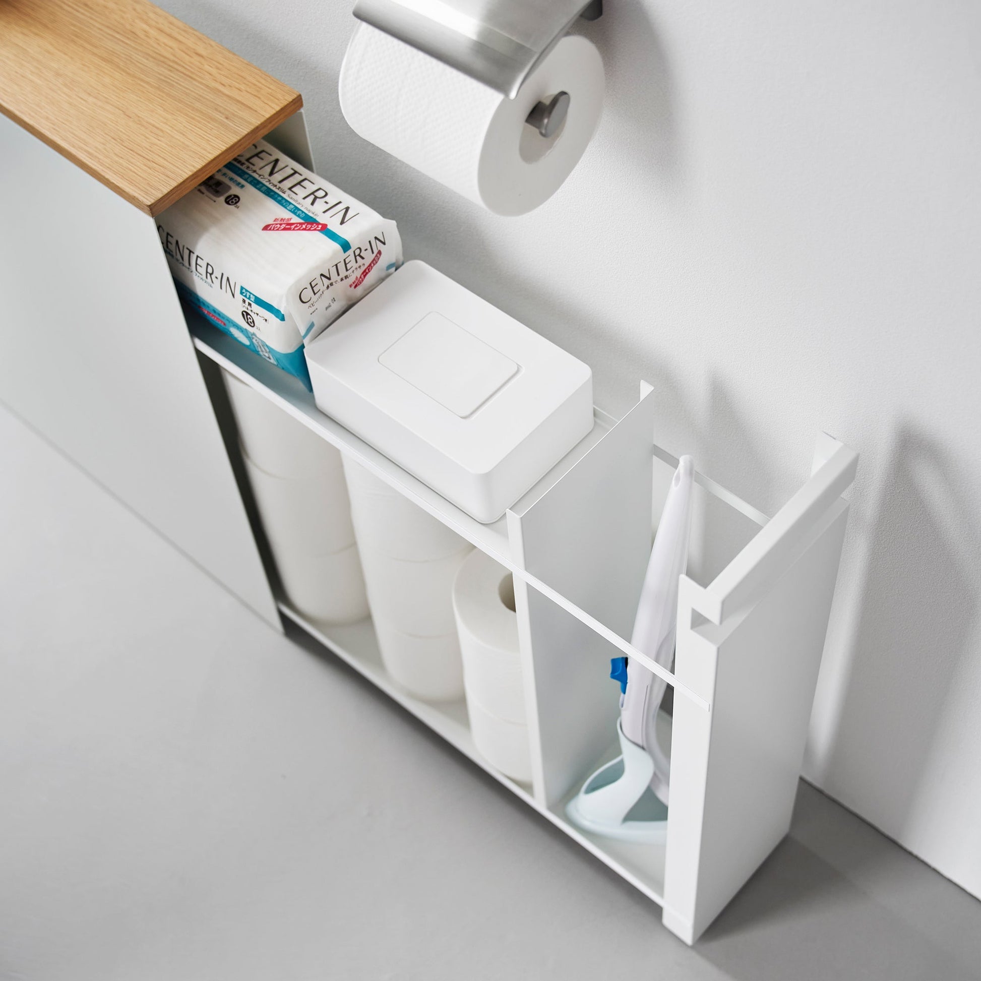 Top-down view of white Yamazaki Home Pull-Out Bathroom Storage Cabinet partially open containing bathroom products