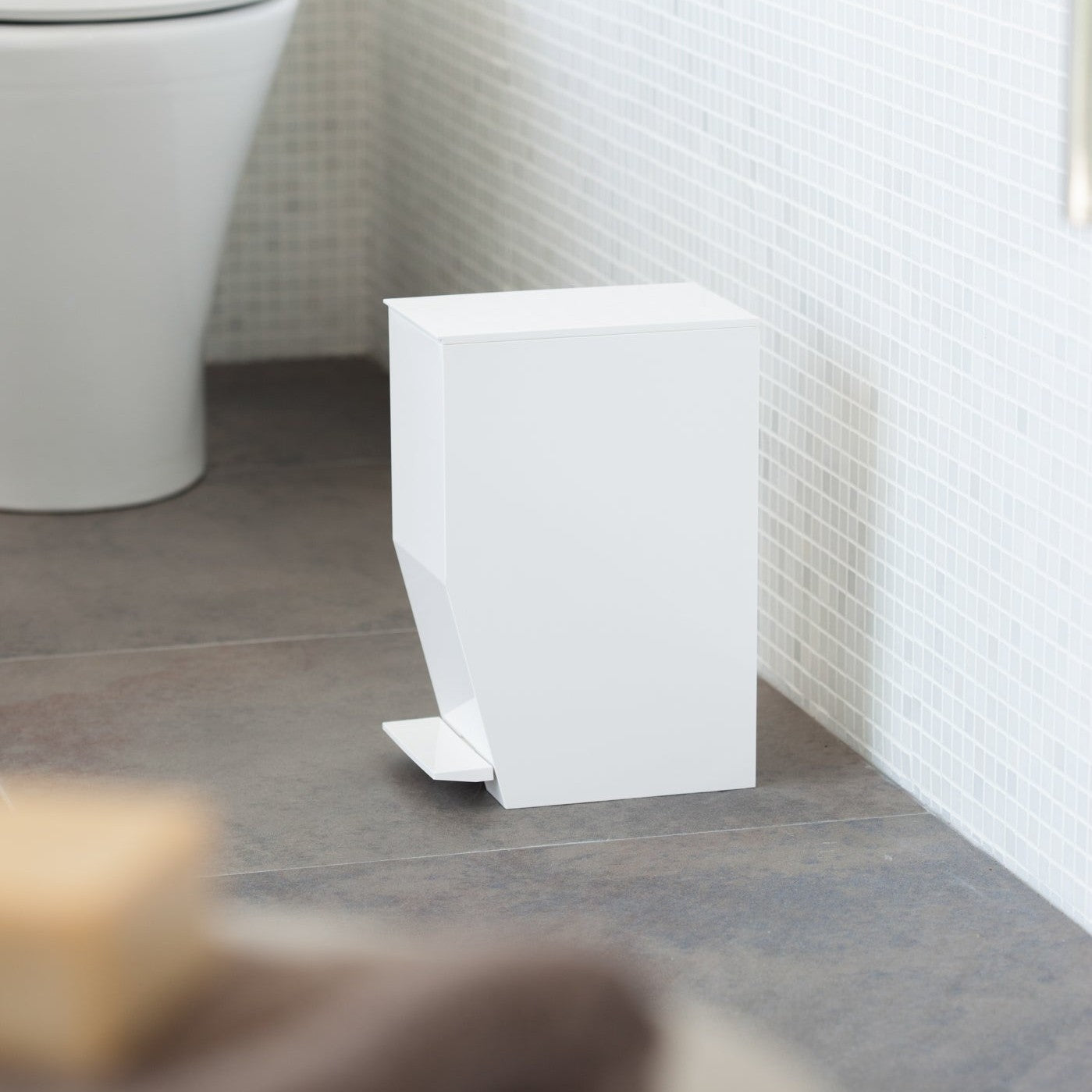 Side view of white Step Trash Can in bathroom by Yamazaki Home.
