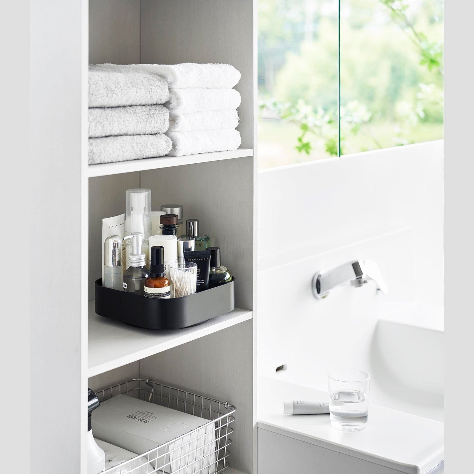 Black Yamazaki Home Rotating Storage Tray with bathroom accessories stored