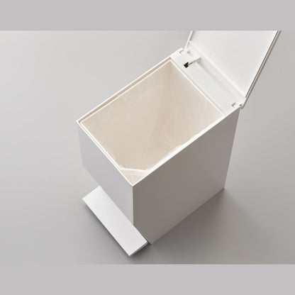 Aerial view of white Step Trash Can open containing plastic bag on white background by Yamazaki Home.