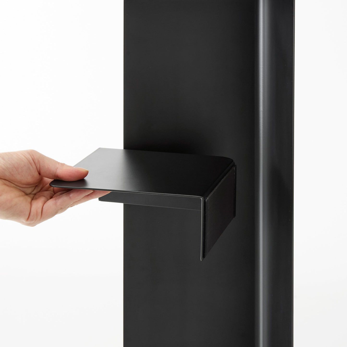 Black Yamazaki Home Rolling Bathroom Organizer magnetic divider being attached to the inside of the base