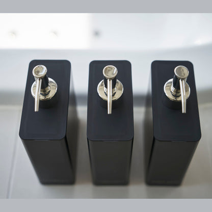 Aerial view of Yamazaki Home black Shampoo, Conditioner, and Body Soap dispensers.