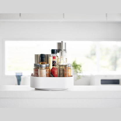 Front view of White Yamazaki Home Rotating Storage Tray with spices and oil stored