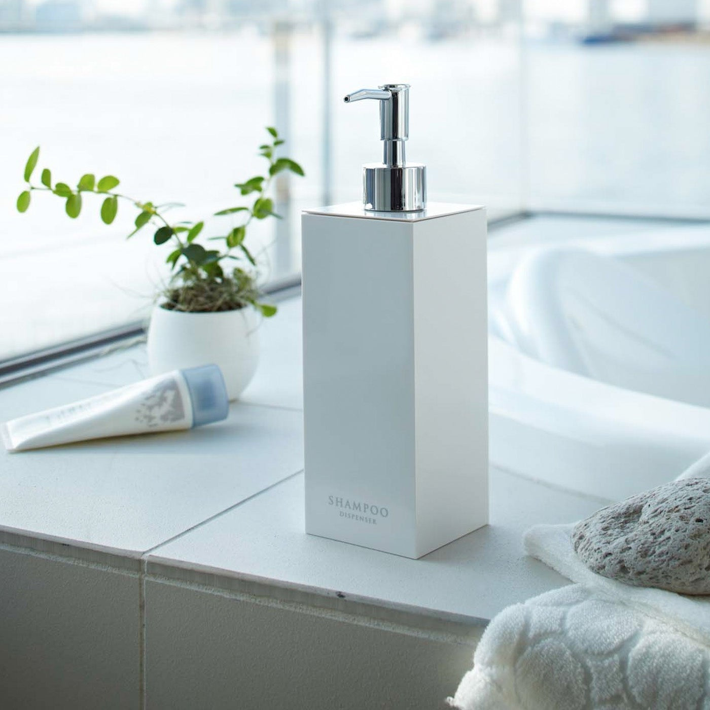 White Yamazaki Home square shampoo dispenser by bathtub