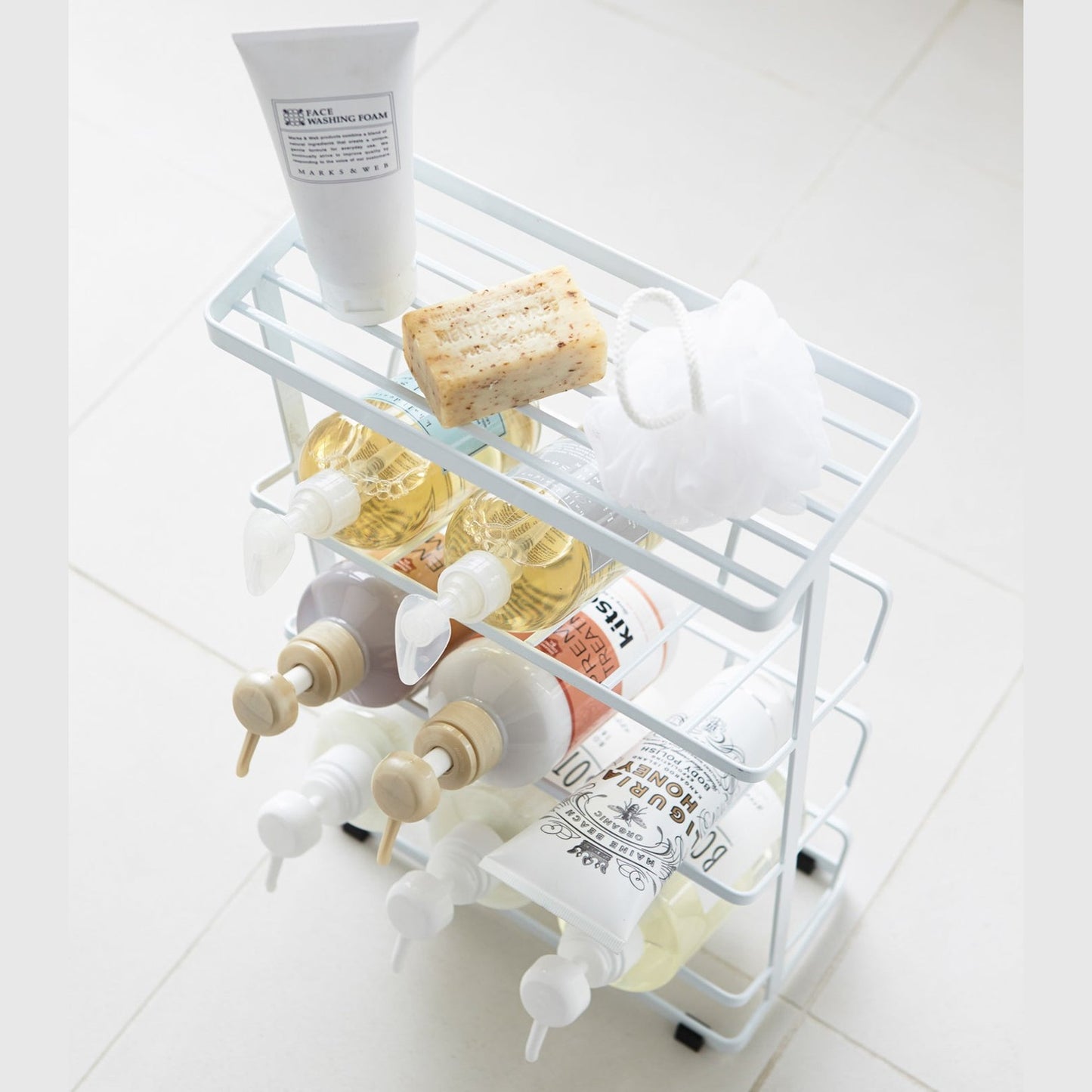Aerial view of white Freestanding Shower Caddy holding beauty products in bathroom by Yamazaki Home.