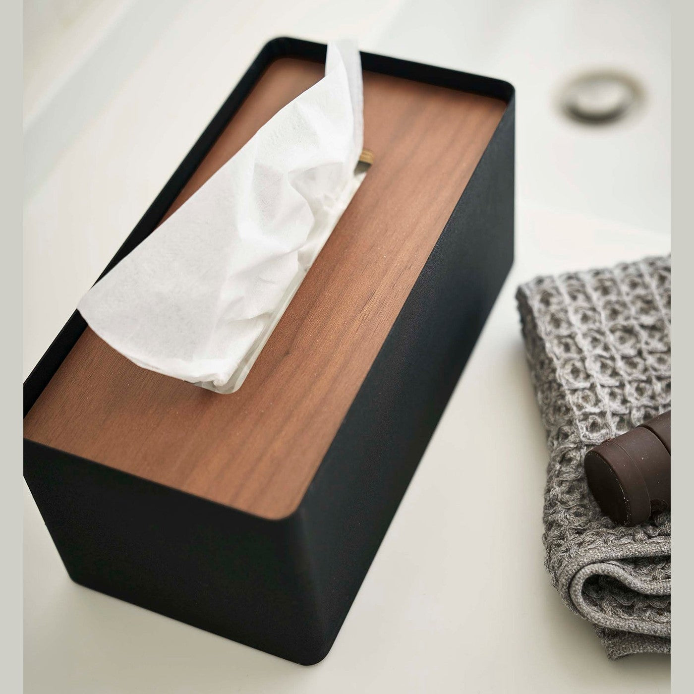 Aerial view of Yamazaki Home black Tissue Case holding tissues on bathroom countertop.