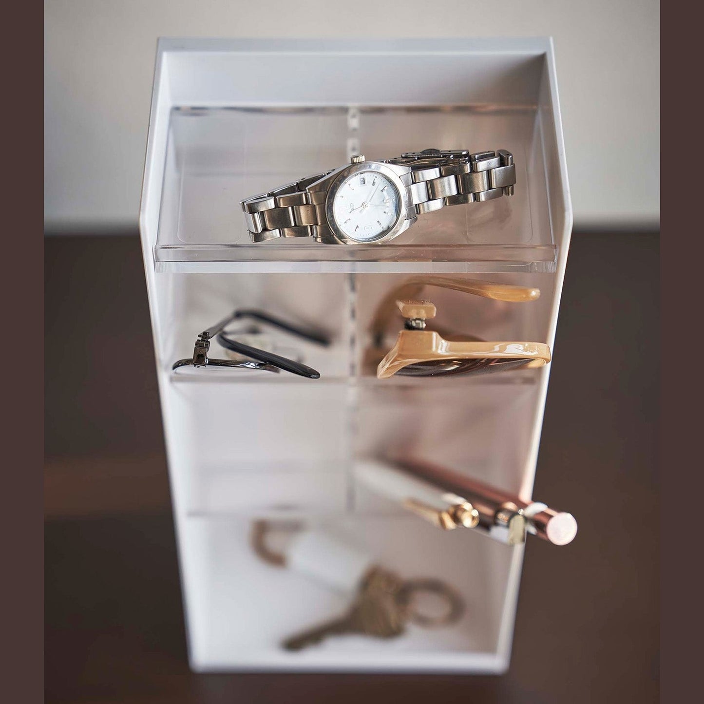 Close up frontal view of white Yamazaki Home Accessory Organizer holding accessories