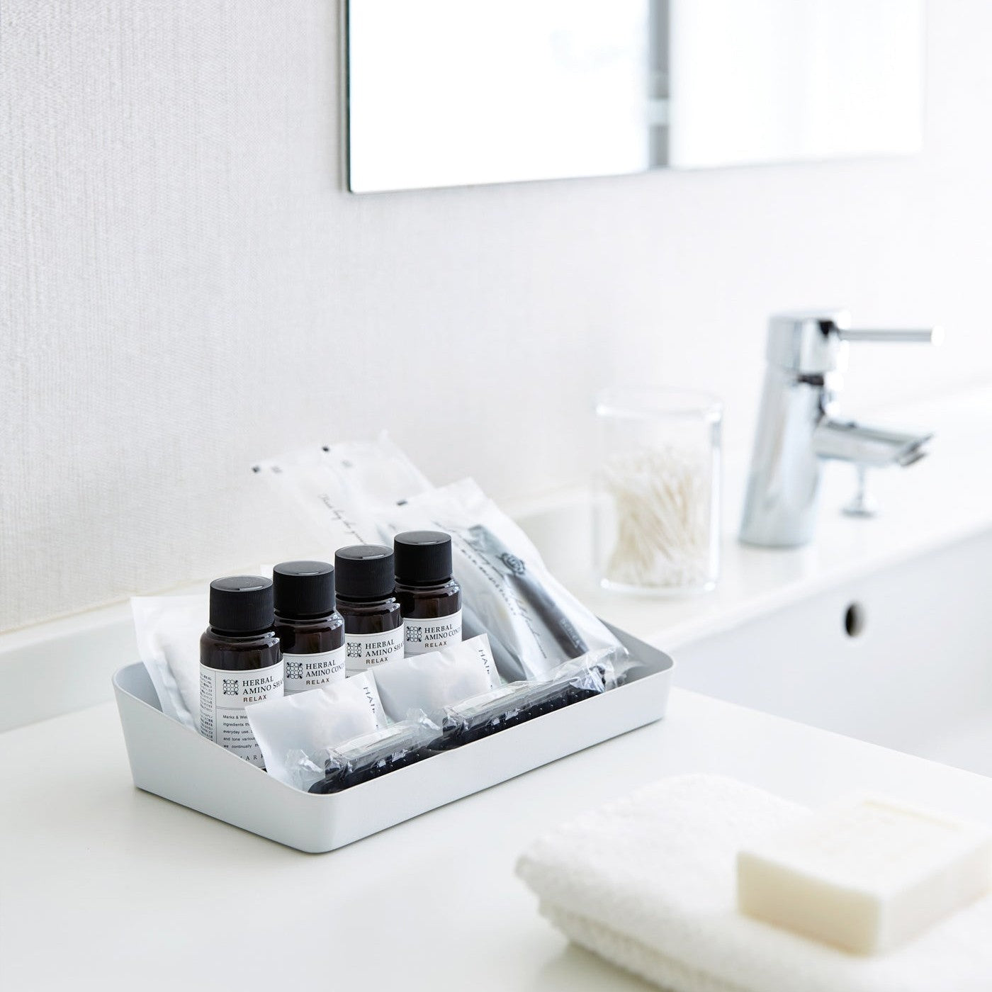 With Accessory Tray with beauty products and oils in bathroom by Yamazaki Home.
