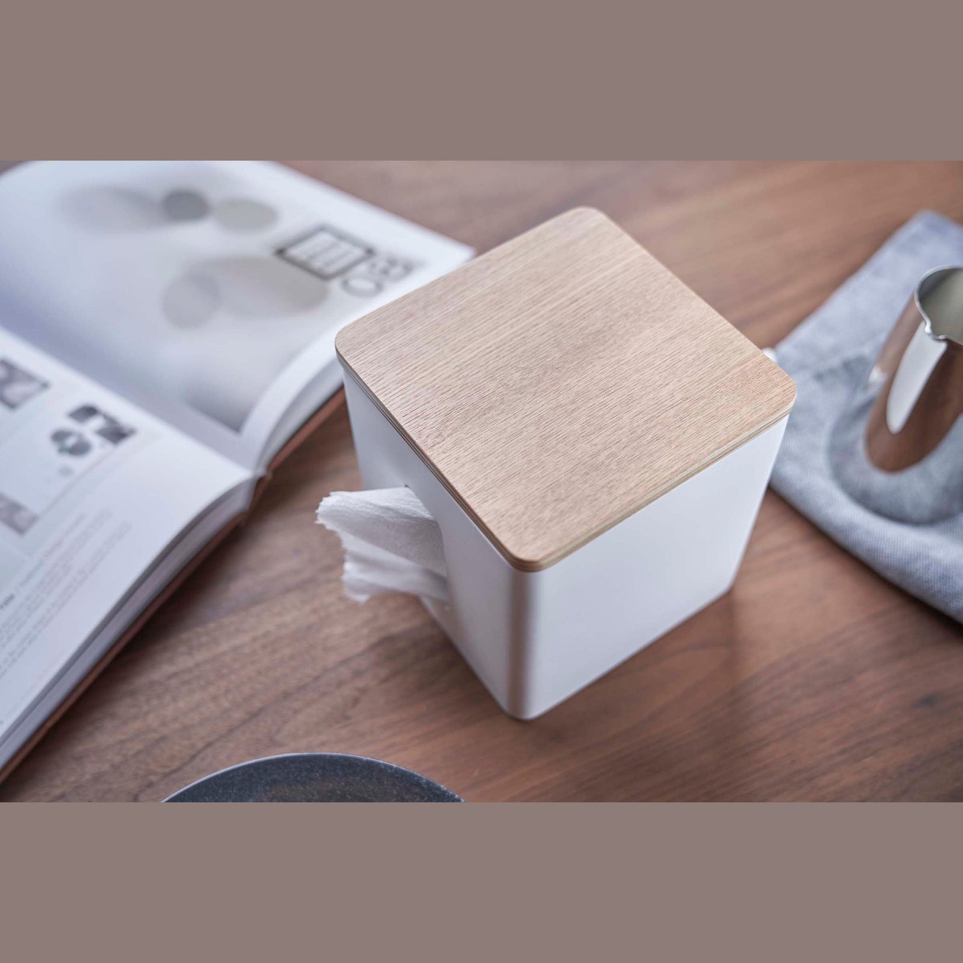 Aerial view of white toilet paper holder on tabletop by Yamazaki Home.