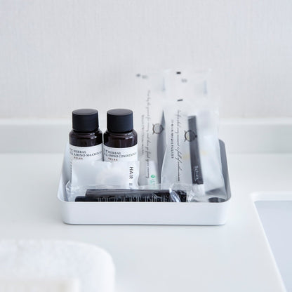 Front view of Accessory Tray holding beauty products in bathroom by Yamazaki Home.