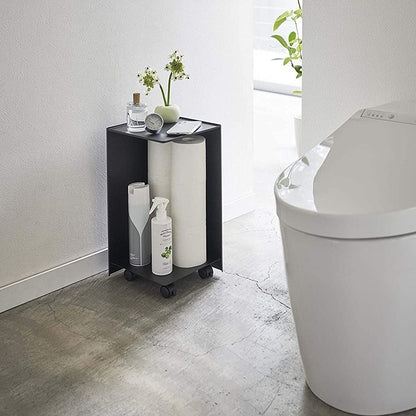 Black Rolling Bathroom Organizer holding toilet paper and supplies in bathroom by Yamazaki Home.