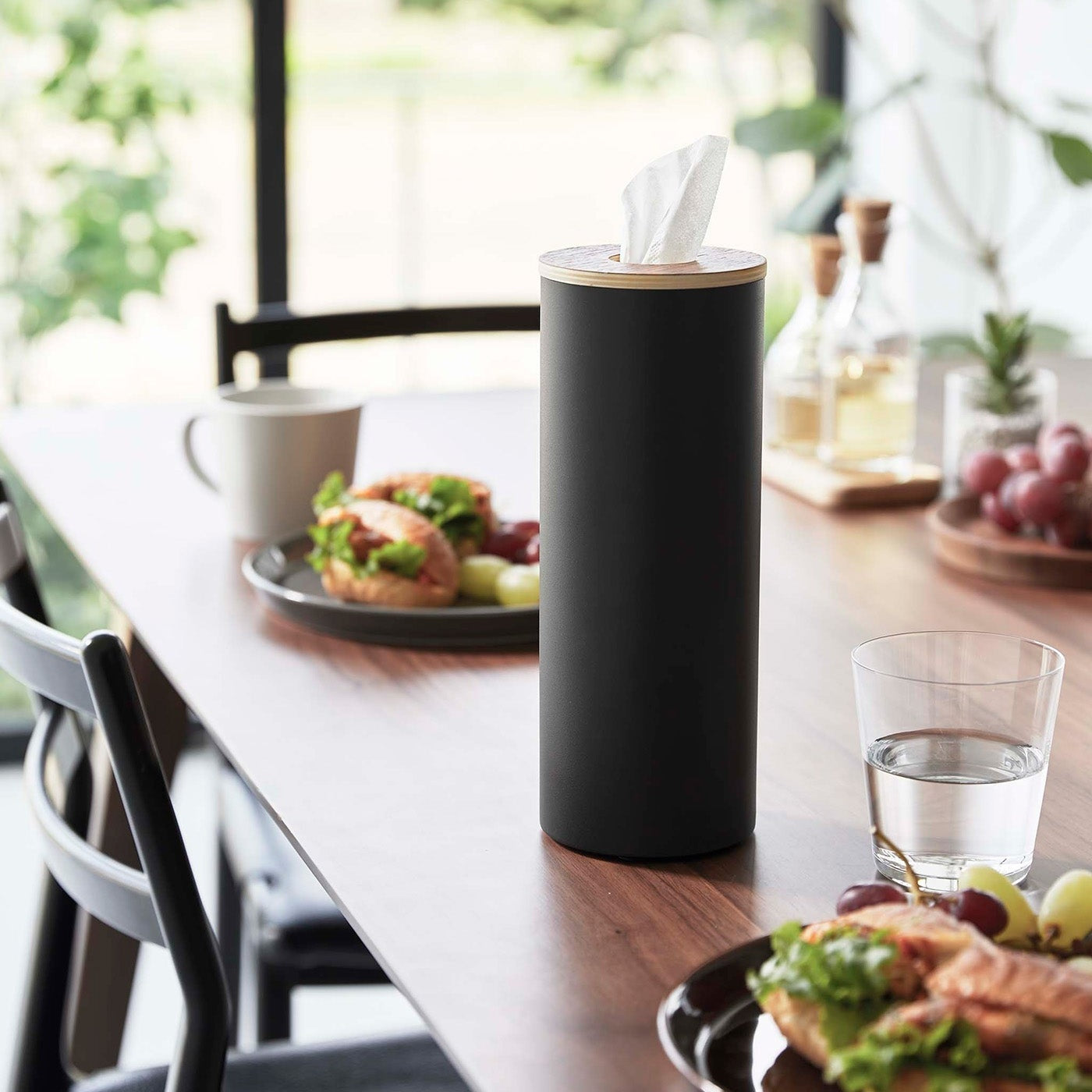 Large black Yamazaki Home Round Tissue Case on a dining table