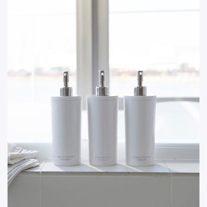 Front view of Yamazaki Home white Shampoo, Conditioner, and Body Soap dispensers in bathroom.