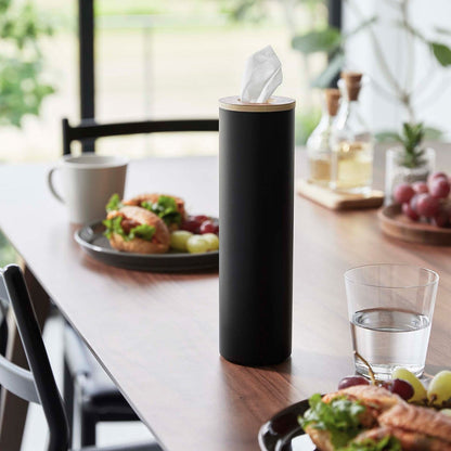 Small black Yamazaki Home Round Tissue Case on a dining table