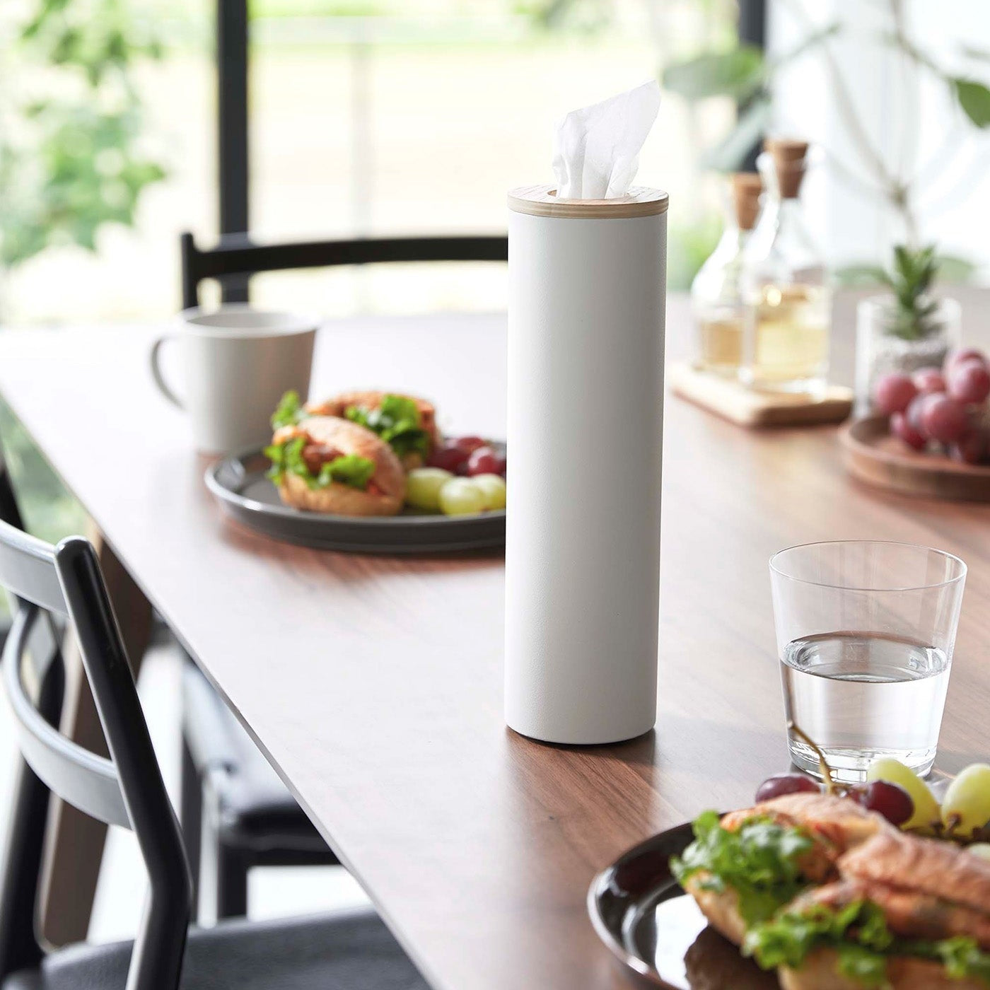 Small white Yamazaki Home Round Tissue Case on a dining table