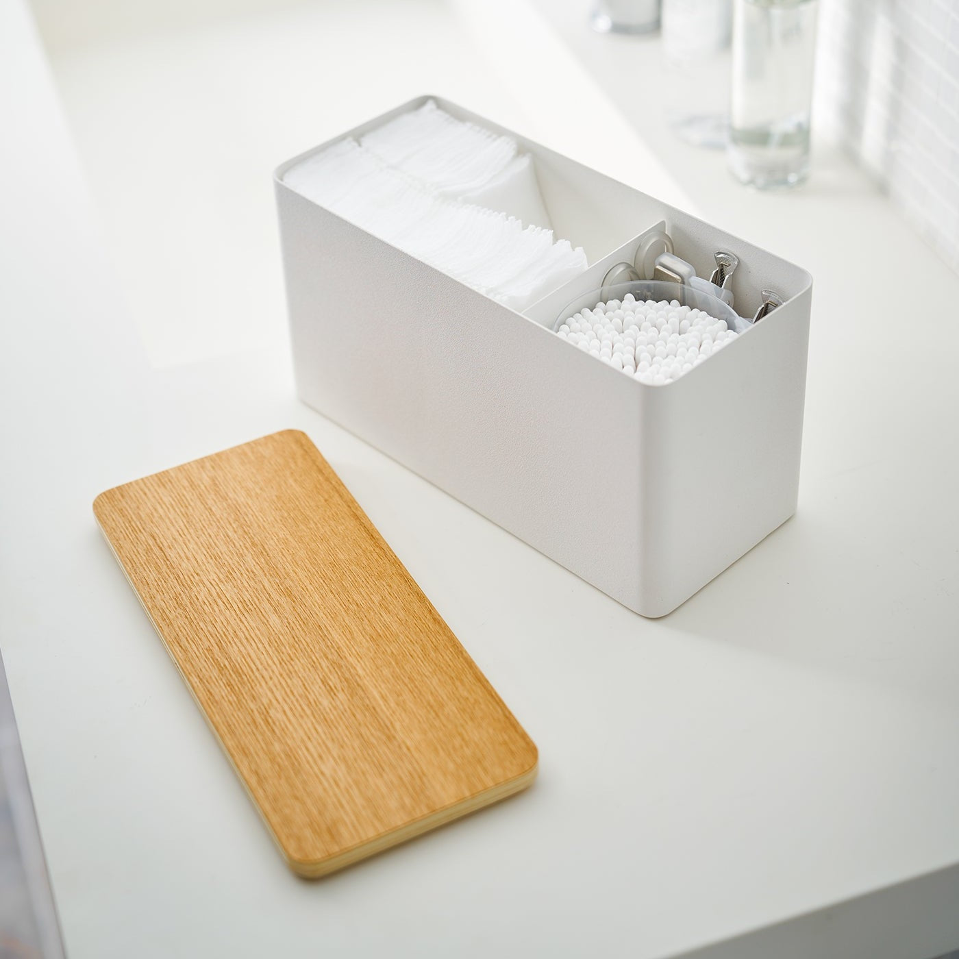 White Countertop Organizer with lid off and holding beauty items on bathroom countertop by Yamazaki Home.