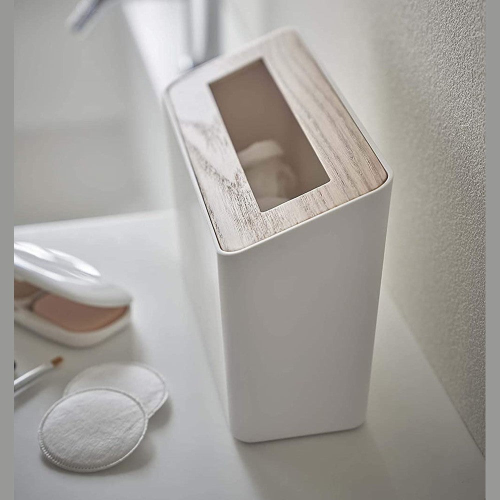 Side view of White Countertop Waste Bin on bathroom sink countertop by Yamazaki Home.