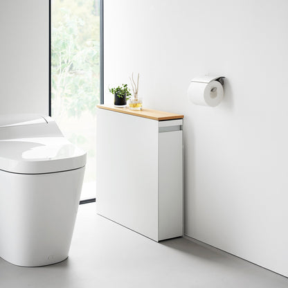 White Yamazaki Home Pull-Out Bathroom Storage Cabinet next to a toilet in a bathroom