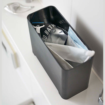 Top-down view of black Yamazaki Self-Draining Bathroom Organizer filled with bathroom products