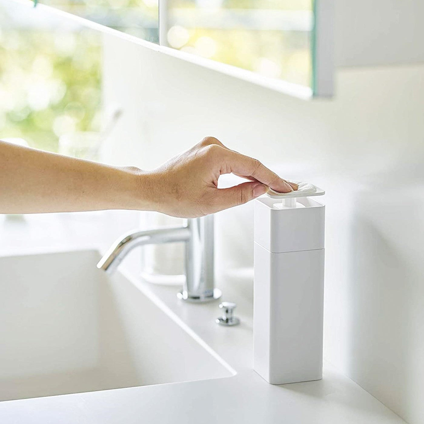 White One-Handed Push Soap Dispenser in bathroom sink countertop by Yamazaki Home.