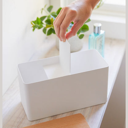 Front view of person inserting divider into white countertop organizer by Yamazaki Home.