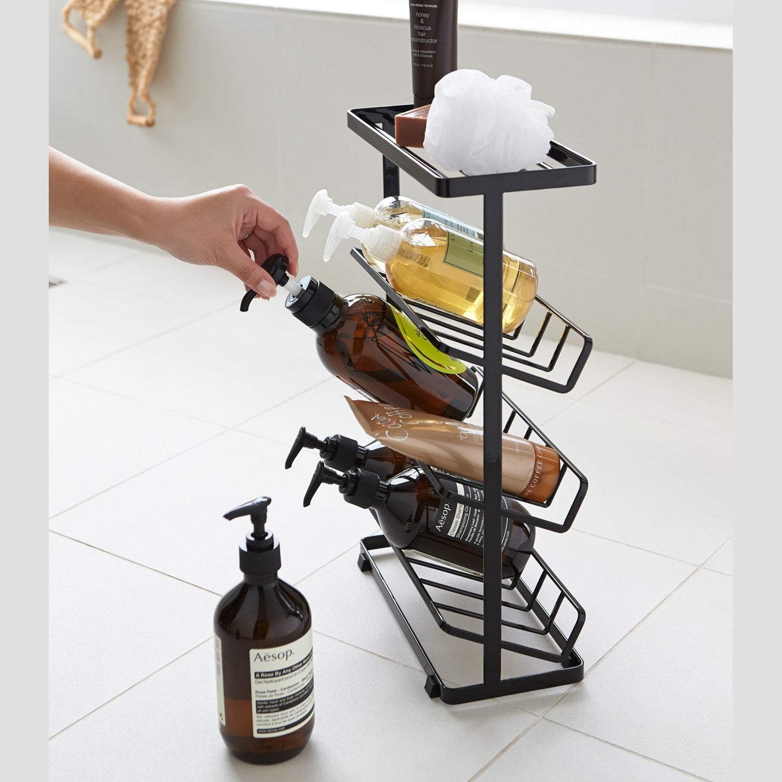 Side view of black Freestanding Shower Caddy holding beauty products by Yamazaki Home.