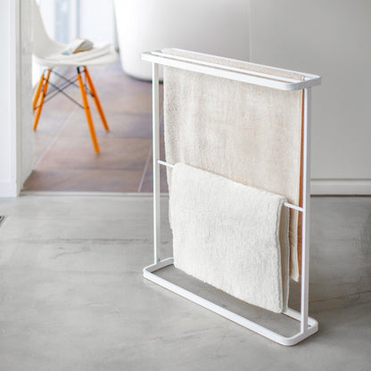 White Bath Towel Hanger holding mat and towel by Yamazaki Home.
