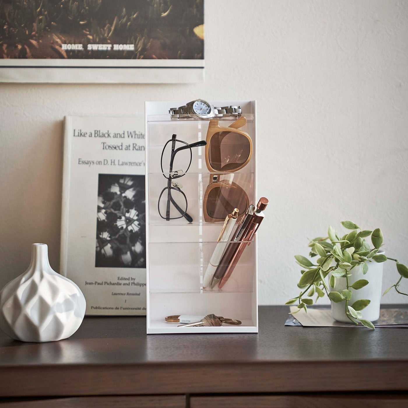 Frontal view of white Yamazaki Home Accessory Organizer holding accessories such as pens and sunglasses