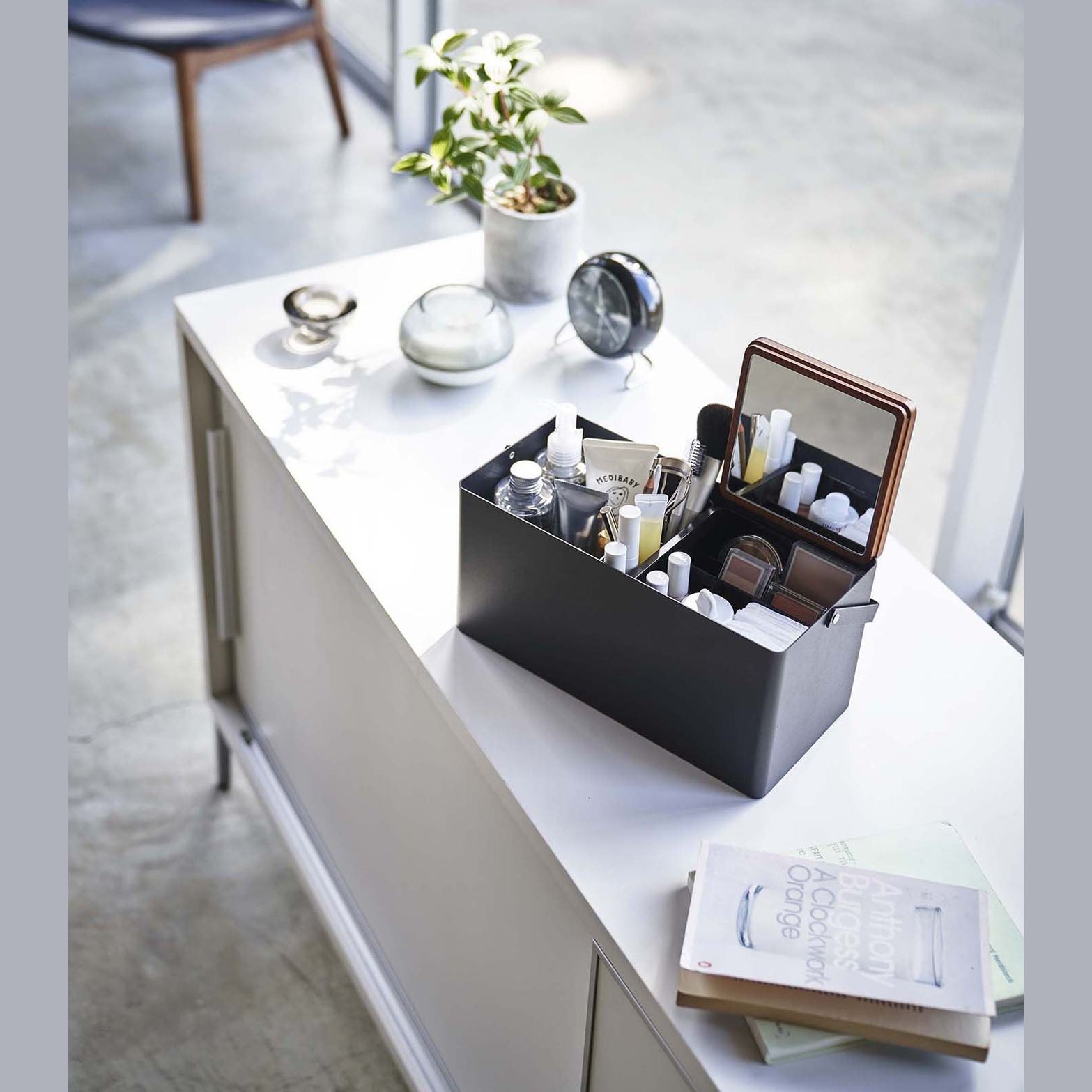 Black Makeup Organizer holding makeup products on table by Yamazaki Home.