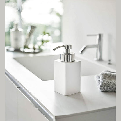 White Foaming Soap Dispenser on bathroom sink countertop by Yamazaki Home.