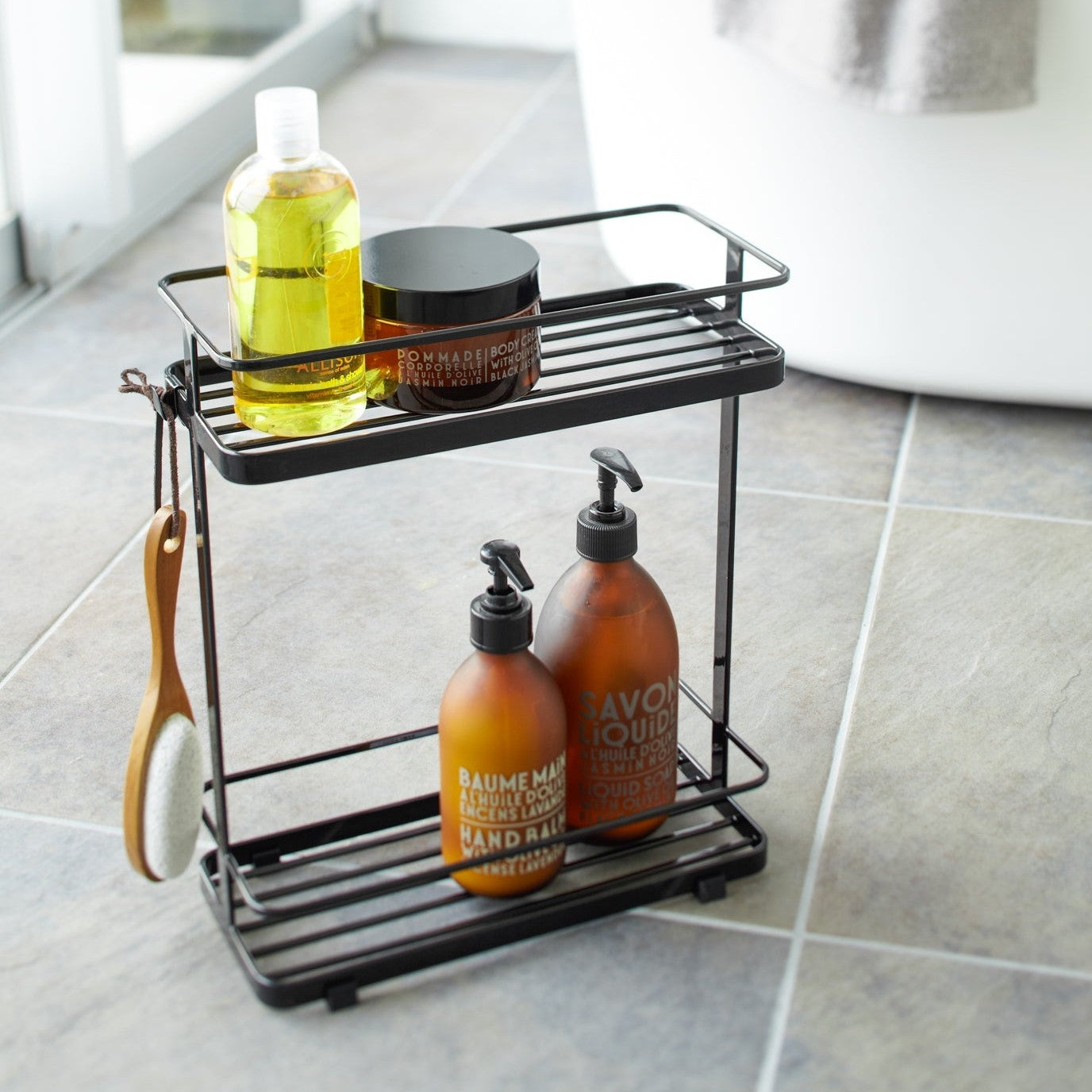Black Shower Caddy holding shower items in bathroom by Yamazaki Home.