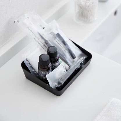 Aerial view of medium black Accessory Tray holding beauty items on bathroom sink counter by Yamazaki Home.