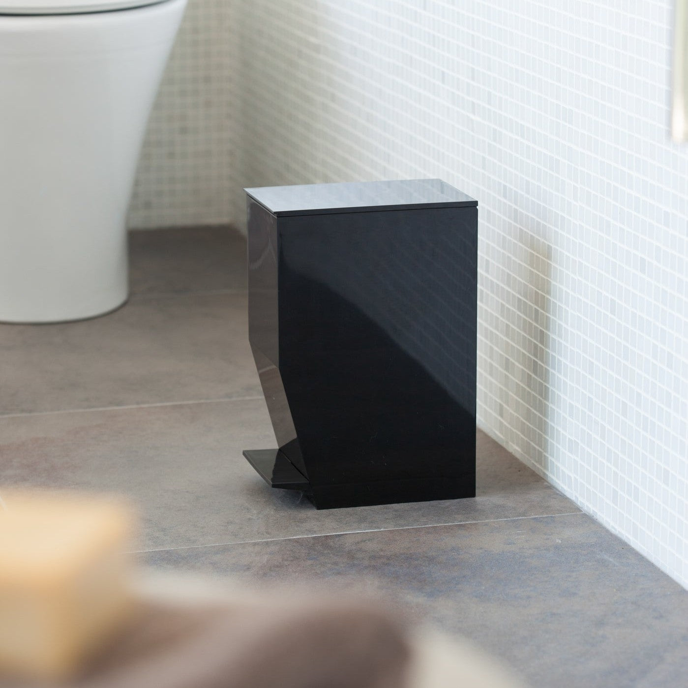 Side view of black Step Trash Can in bathroom by Yamazaki Home.