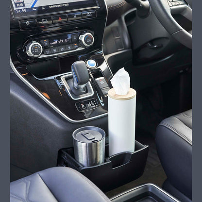 Small white Yamazaki Home Round Tissue Case in the center console cup holder of a car