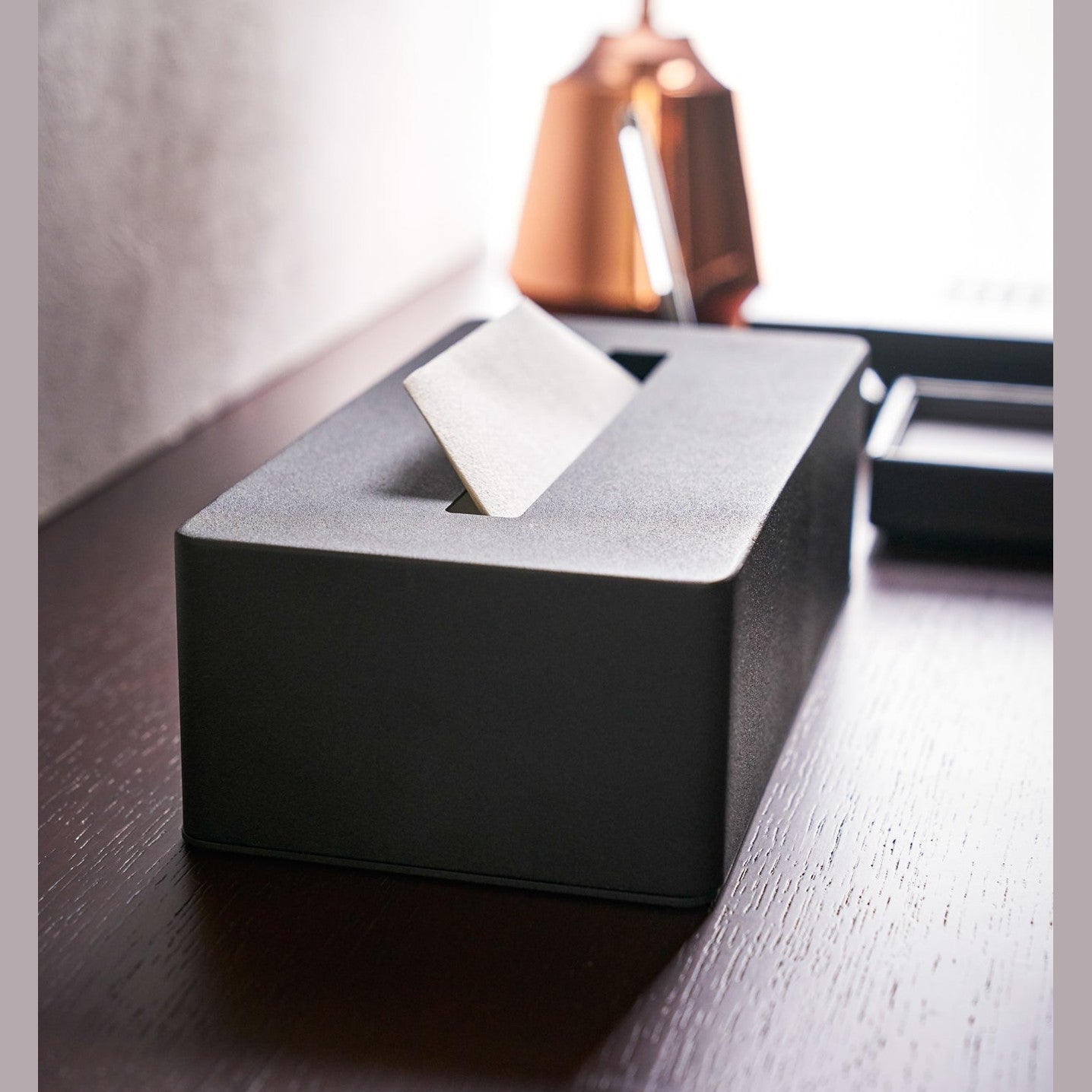 Side view of black Tissue Case on desk by Yamazaki Home.
