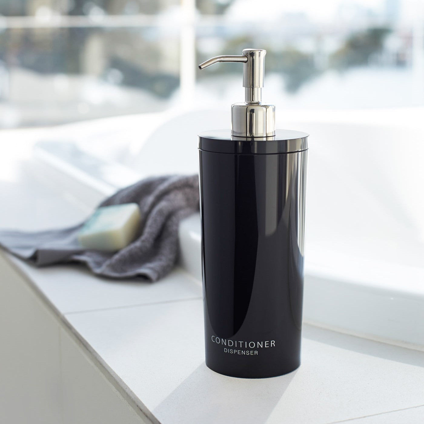 Front view of black Conditioner Dispenser in bathroom by Yamazaki Home.
