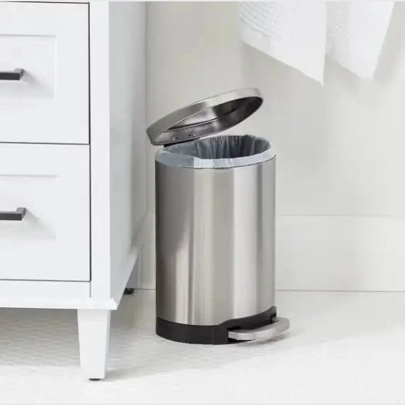 Hands-free stainless steel trash can on bathroom vanity with open lid