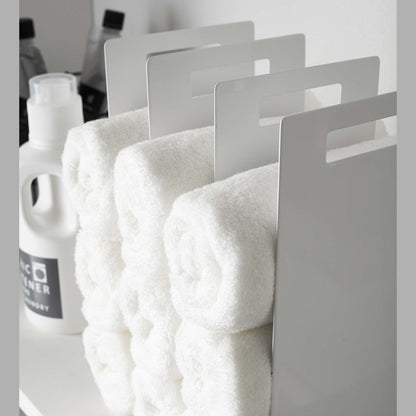 Close up side view of white Towel Storage Organizer holding towels by Yamazaki Home.