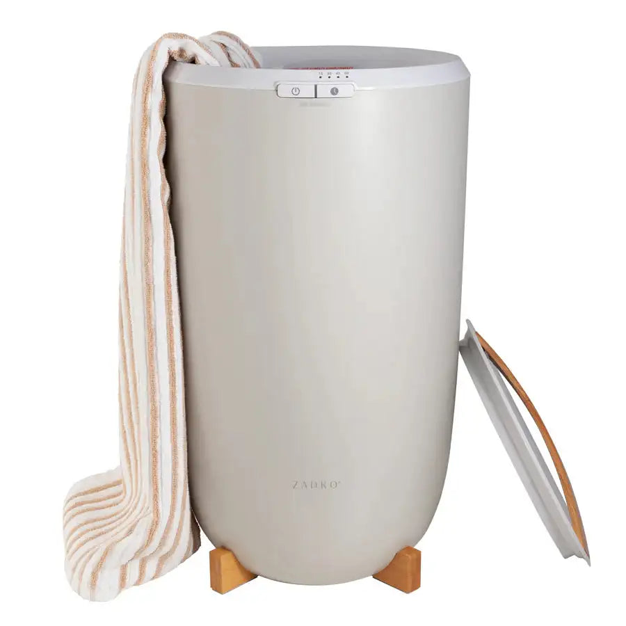 Beige Zadro towel warmer holding striped bath towel with lid open