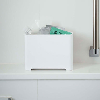 Frontal view of white Yamazaki Self-Draining Bathroom Organizer filled with bath supplies