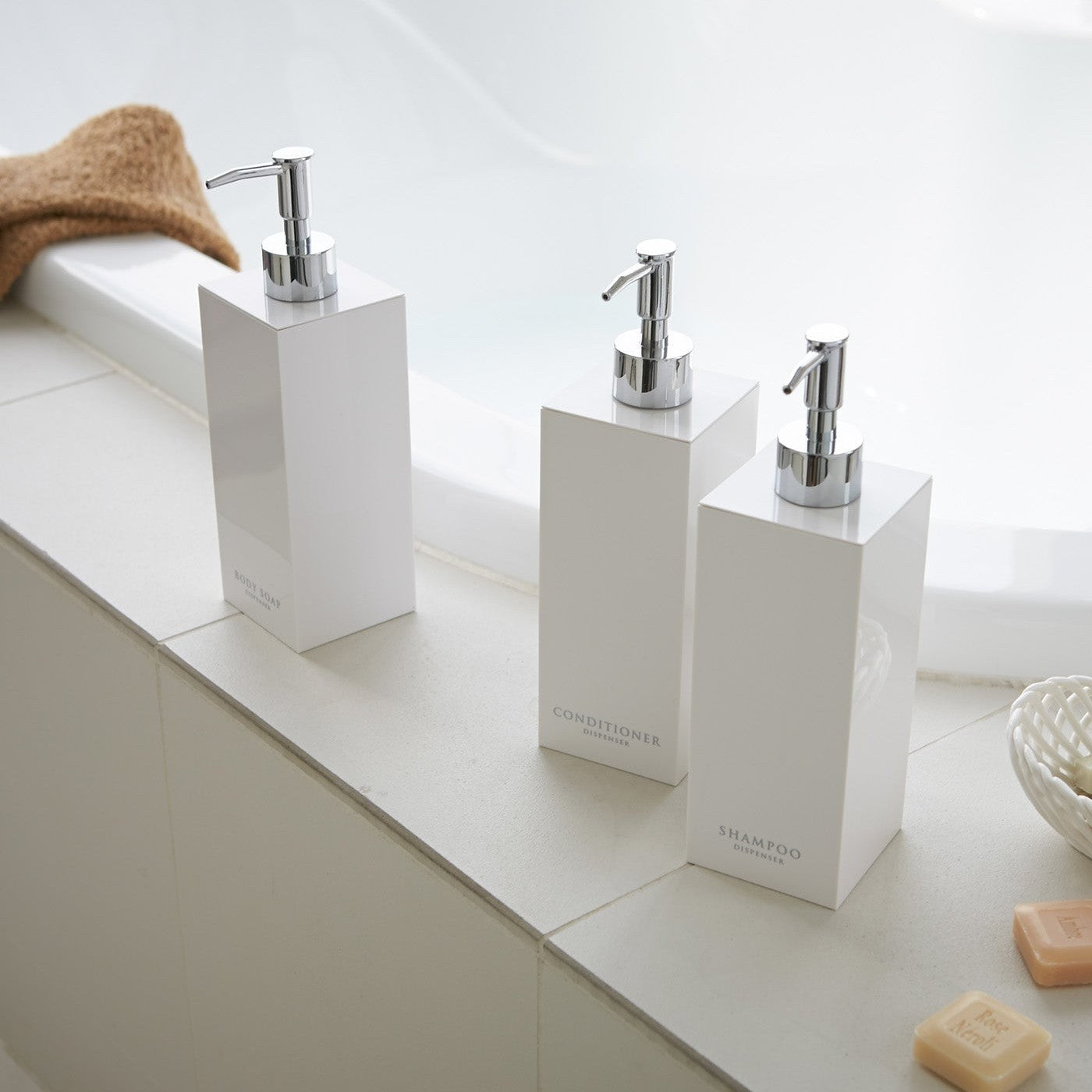 White Yamazaki Home square soap dispenser in three styles by bathtub