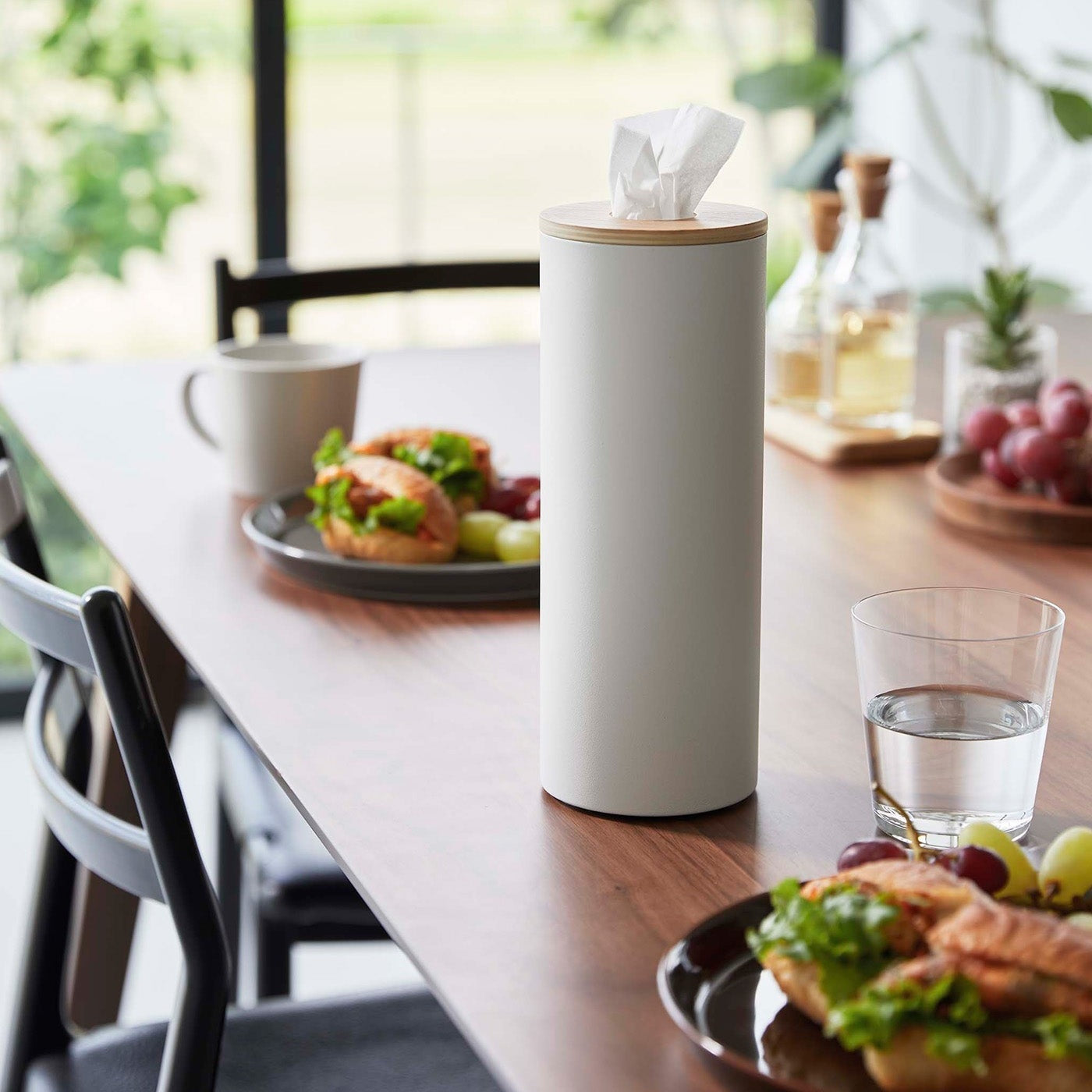 Large White Yamazaki Home Round Tissue Case on a dining table with food