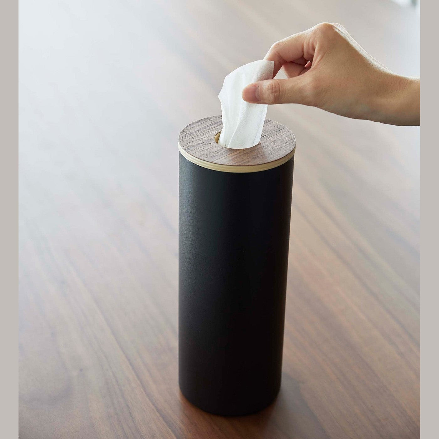 Large black Yamazaki Home Round Tissue Case and a tissue being pulled out