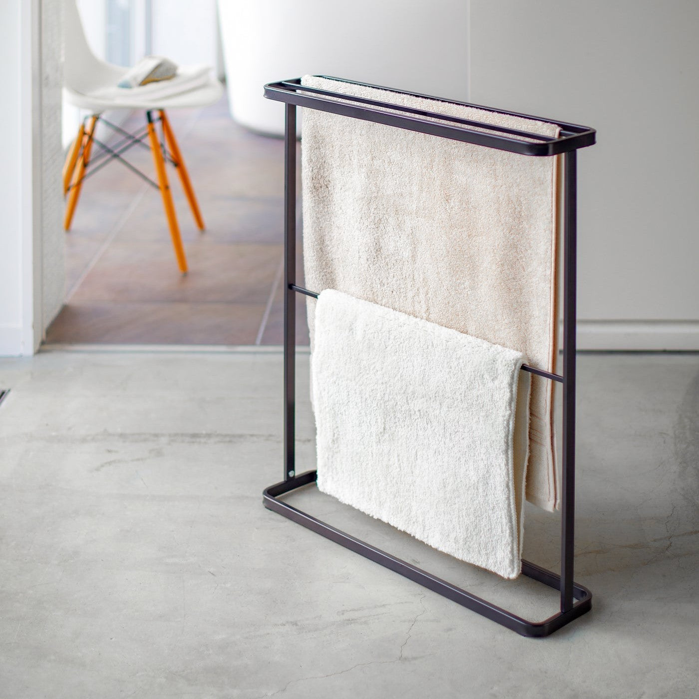 Black Bath Towel Hanger holding towel and mat by Yamazaki Home.