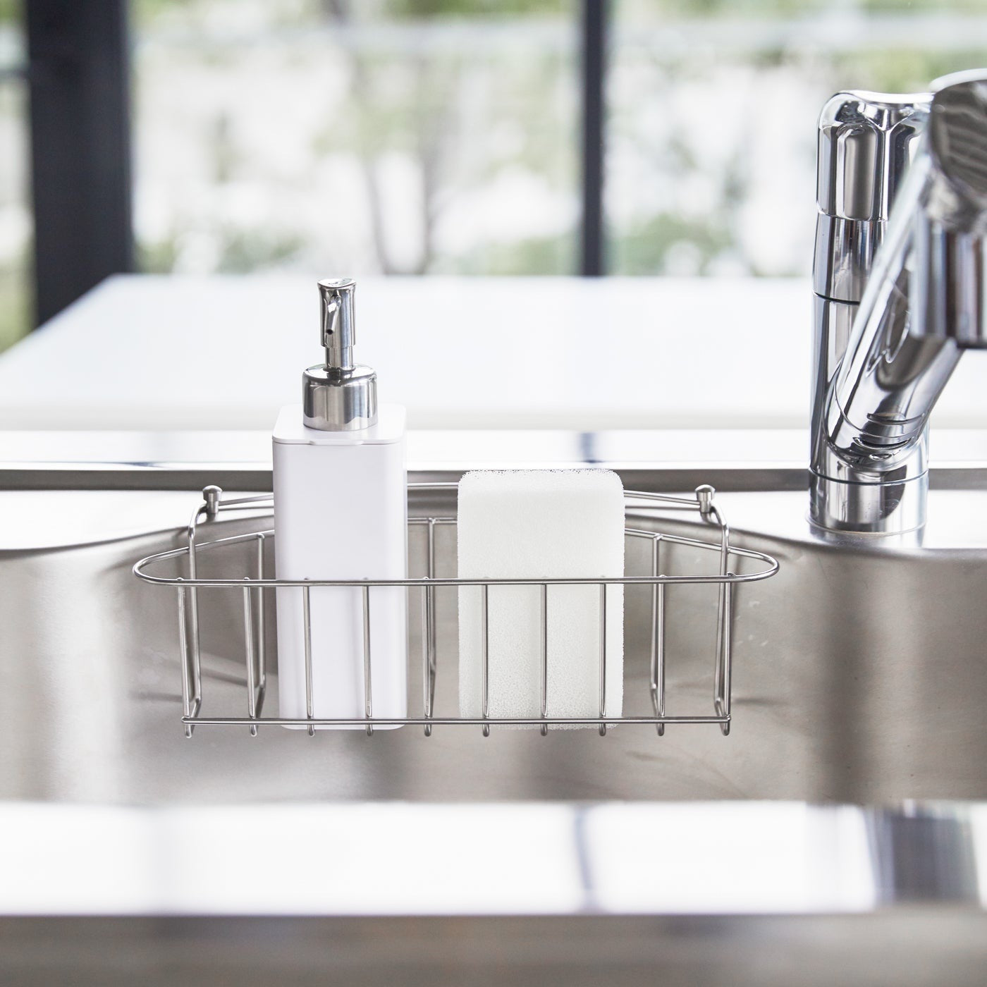 Front view of white Hand Soap Dispenser in kitchen sink by Yamazaki Home.
